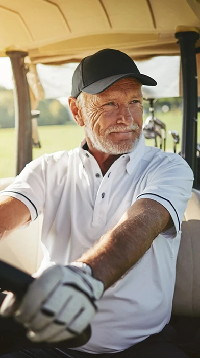 senior man driving golf cart