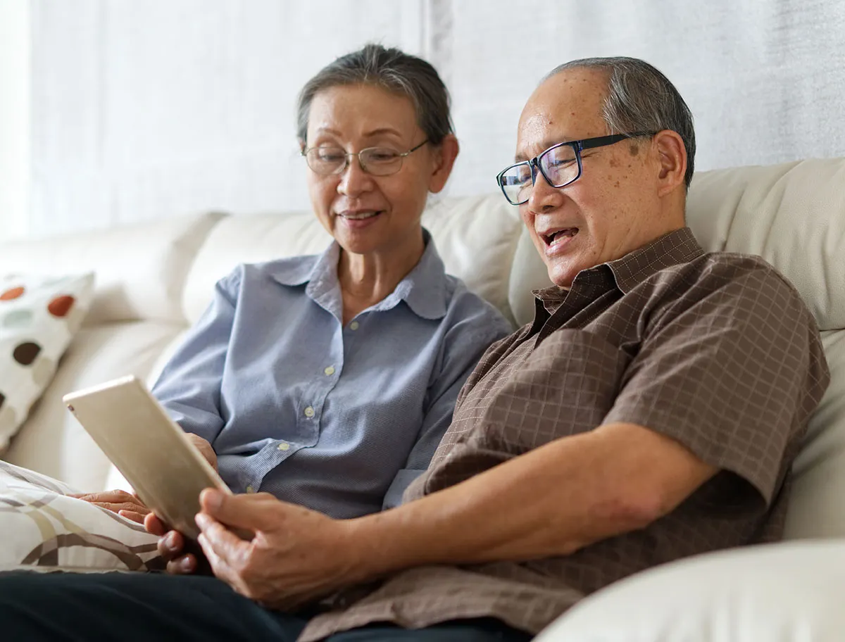 senior couple in glasses looking at tablet